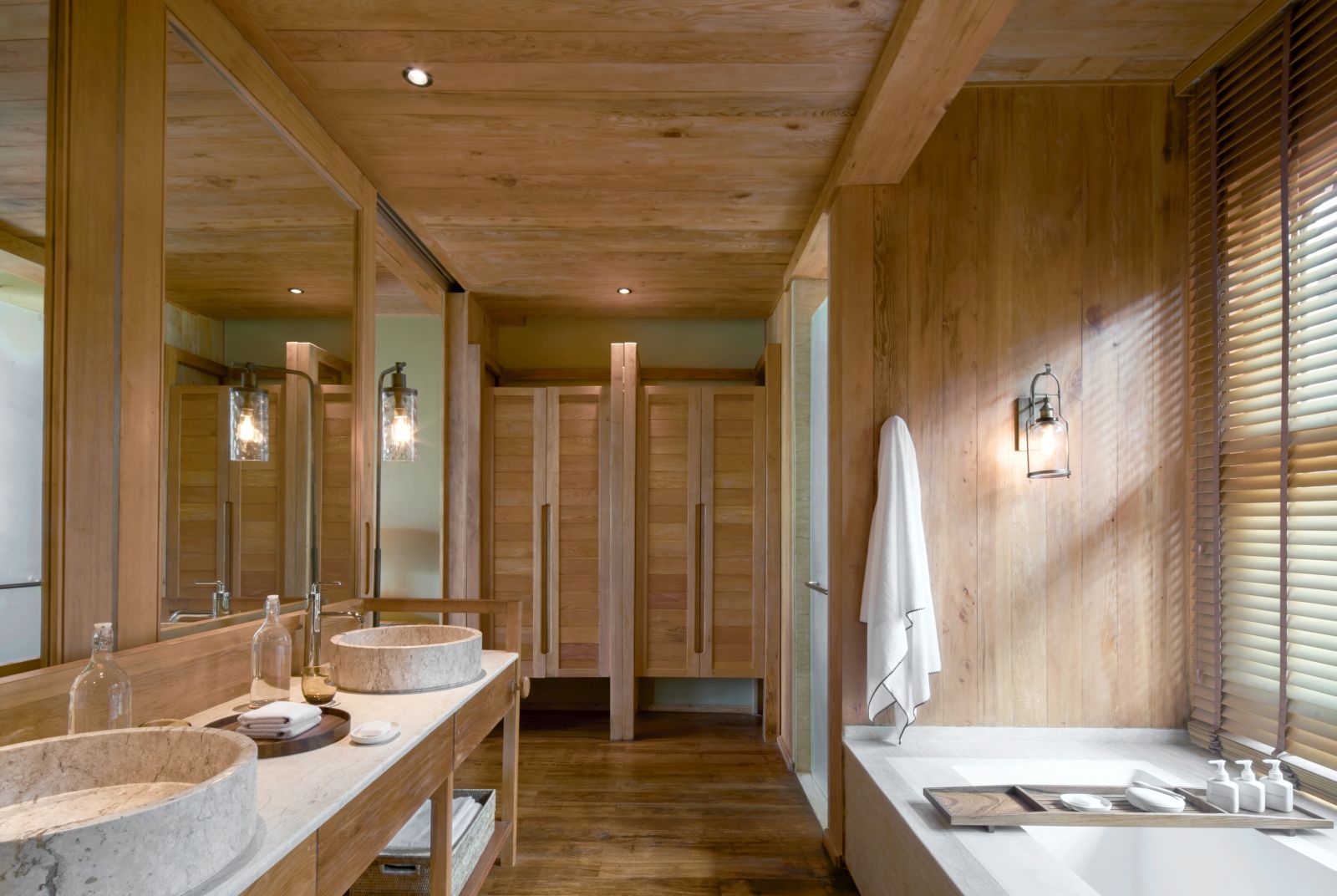 Wooden panelled bathroom with bath and dual sinks