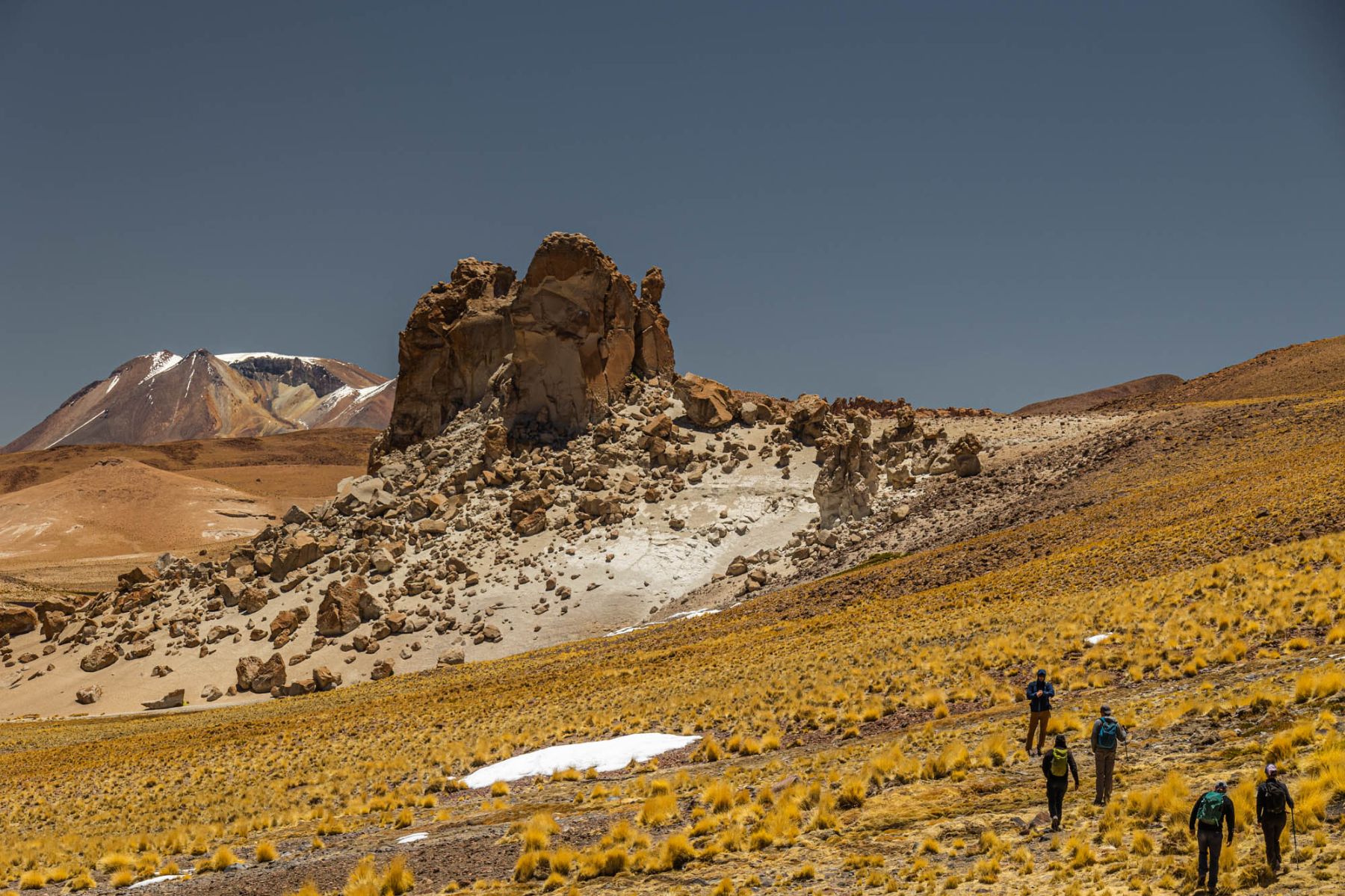 Guests of the Explora Travesia hiking past rock formations in the Bolivian Altiplano
