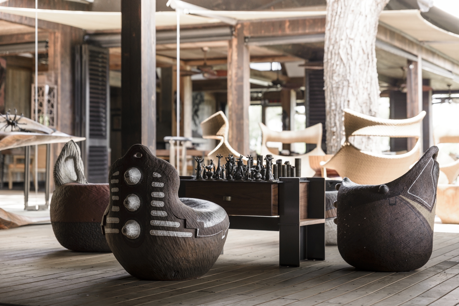 Sitting area with African-themed chairs and chess table at luxury safari camp Xigera in the Okavango Delta, Botswana