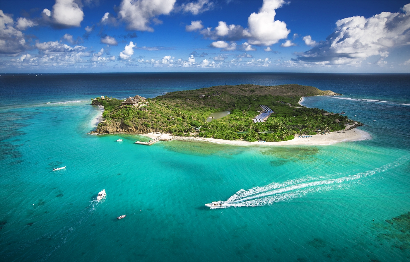 Aerial shot of Necker Island with boats in the turquoise sea