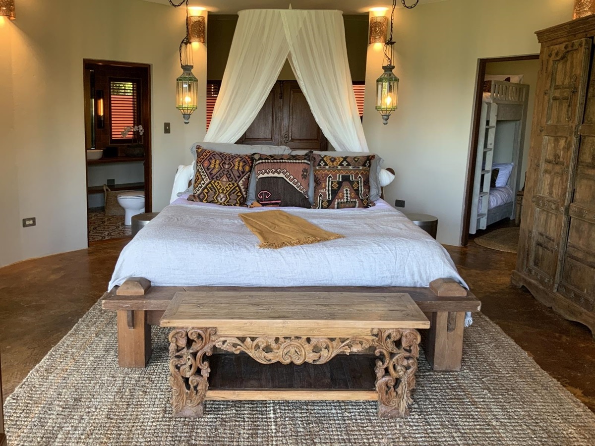 Double bed with wooden furniture and warm tone cushions