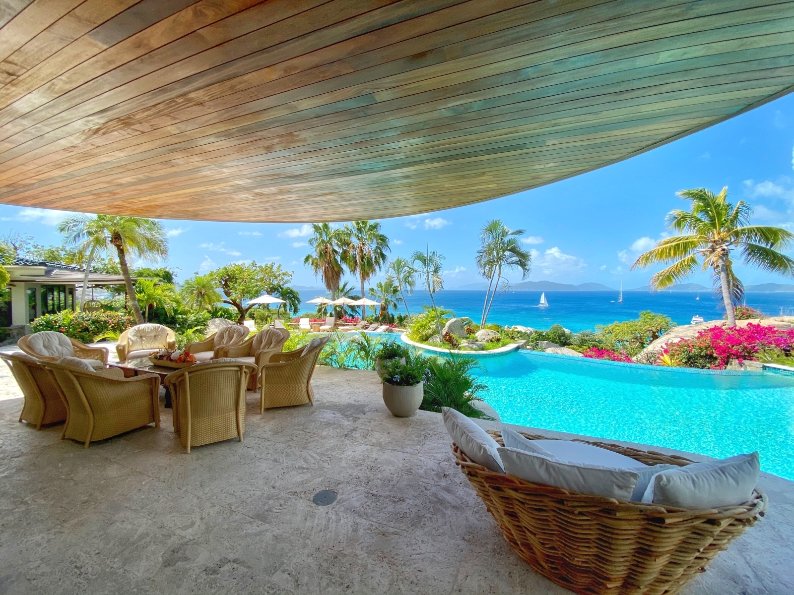 Terrace next to pool with comfy chairs, table and sea view at Valley Trunk on the British Virgin Islands, Caribbean