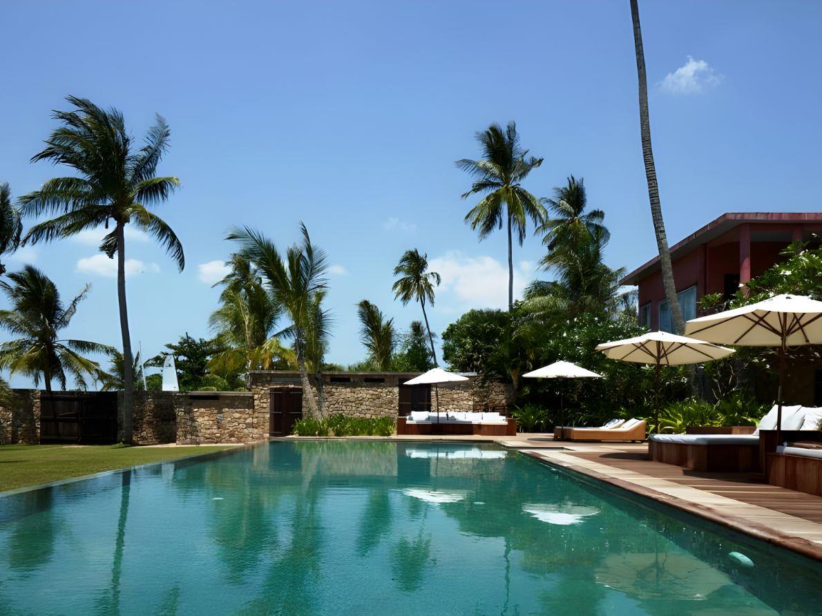 Poolside and sunbeds at Knai Bang Chatt resort in Cambodia