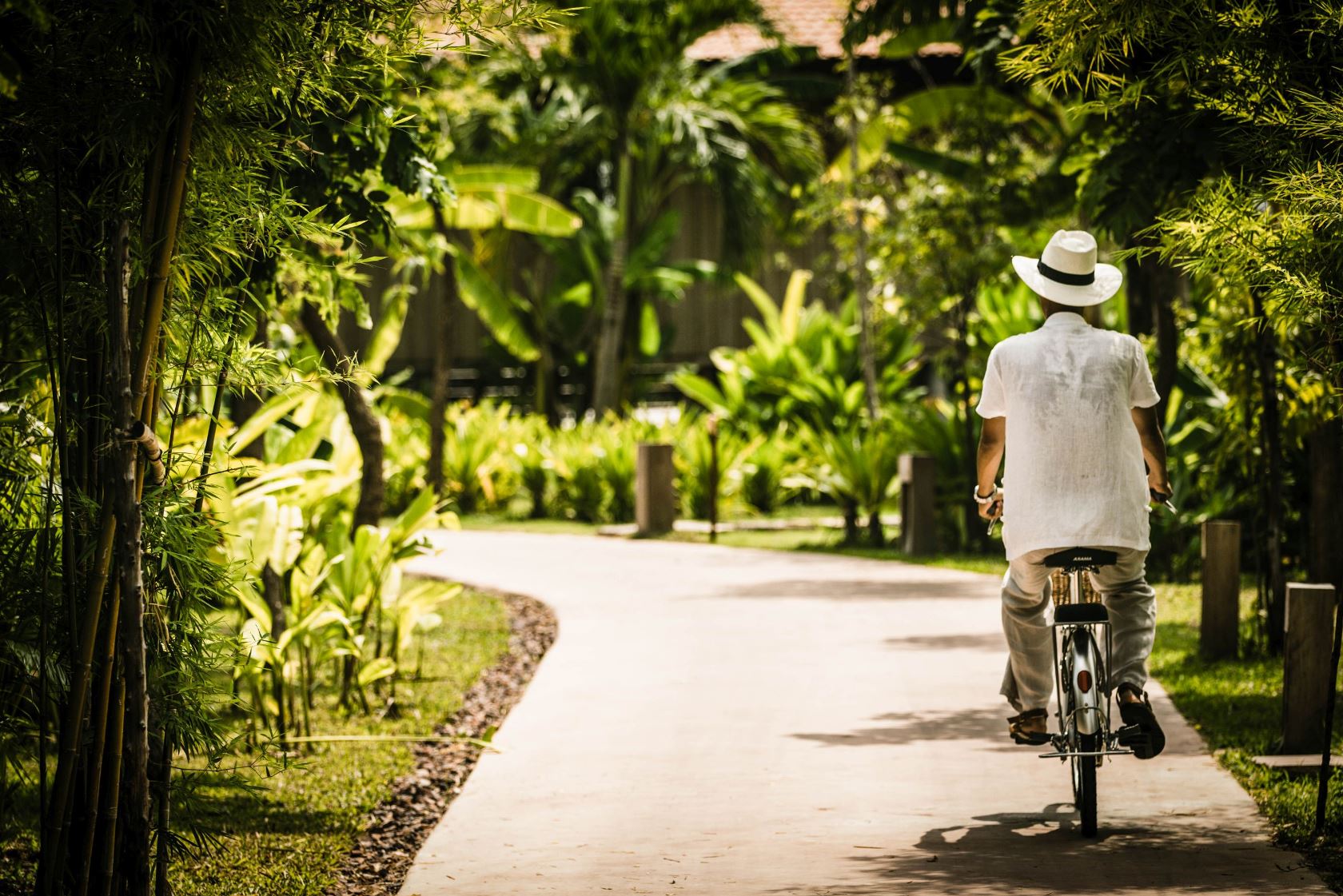 Guest cycling through the lush surroundings of Phum Baitang hotel in Cambodia