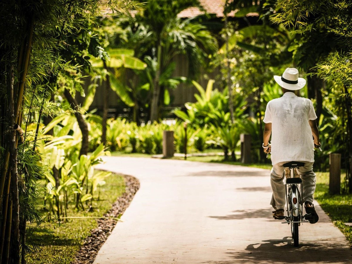 Guest cycling through the lush surroundings of Phum Baitang hotel in Cambodia