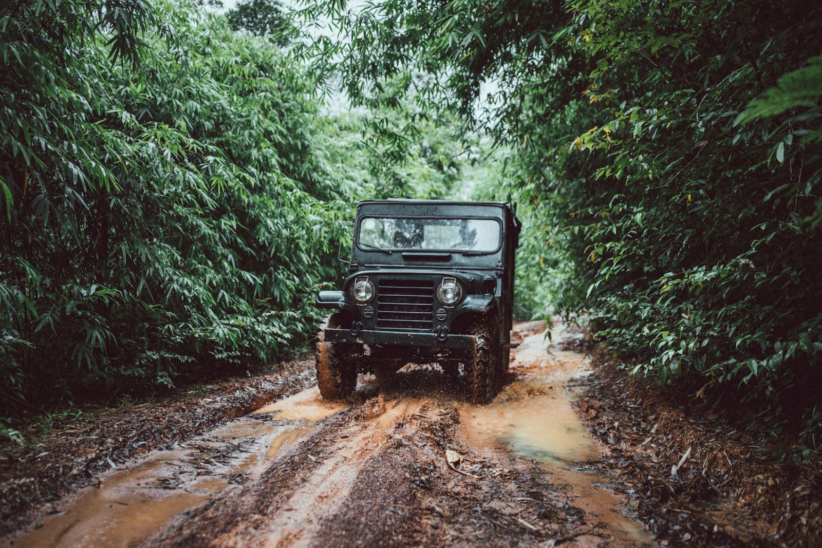 Jeep driving through a muddy road at Luxury resort Shinta Mani Wild 