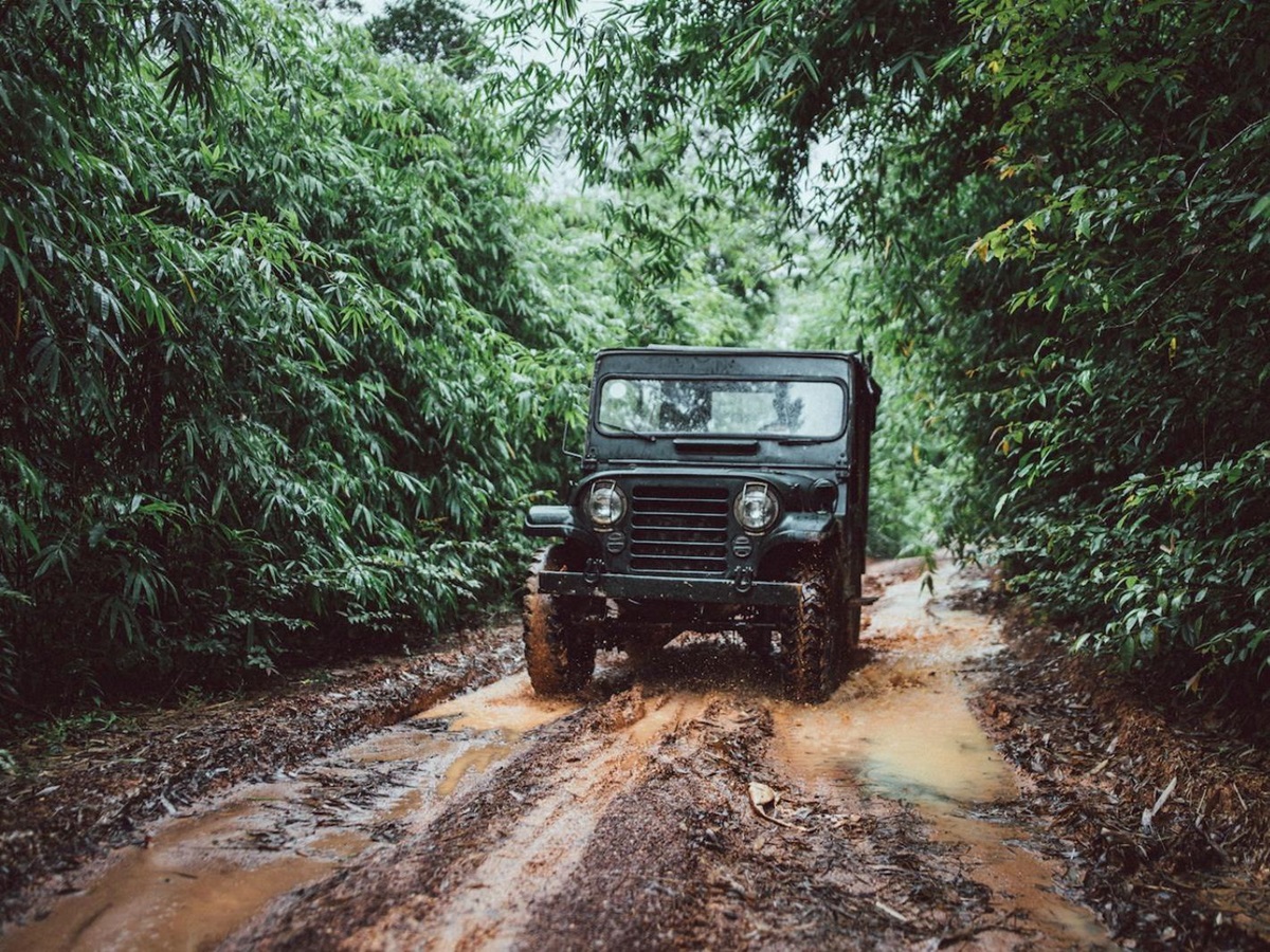 Jeep driving through a muddy road at Luxury resort Shinta Mani Wild
