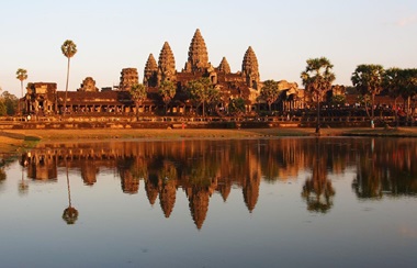 Angkor Wat temple during sunrise reflecting onto the lake below