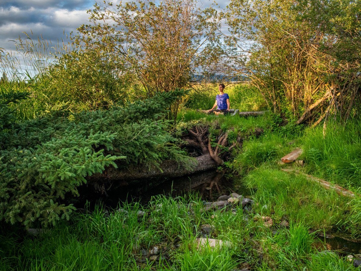 A women meditating in the wilderness at luxury ranch Echo Valley