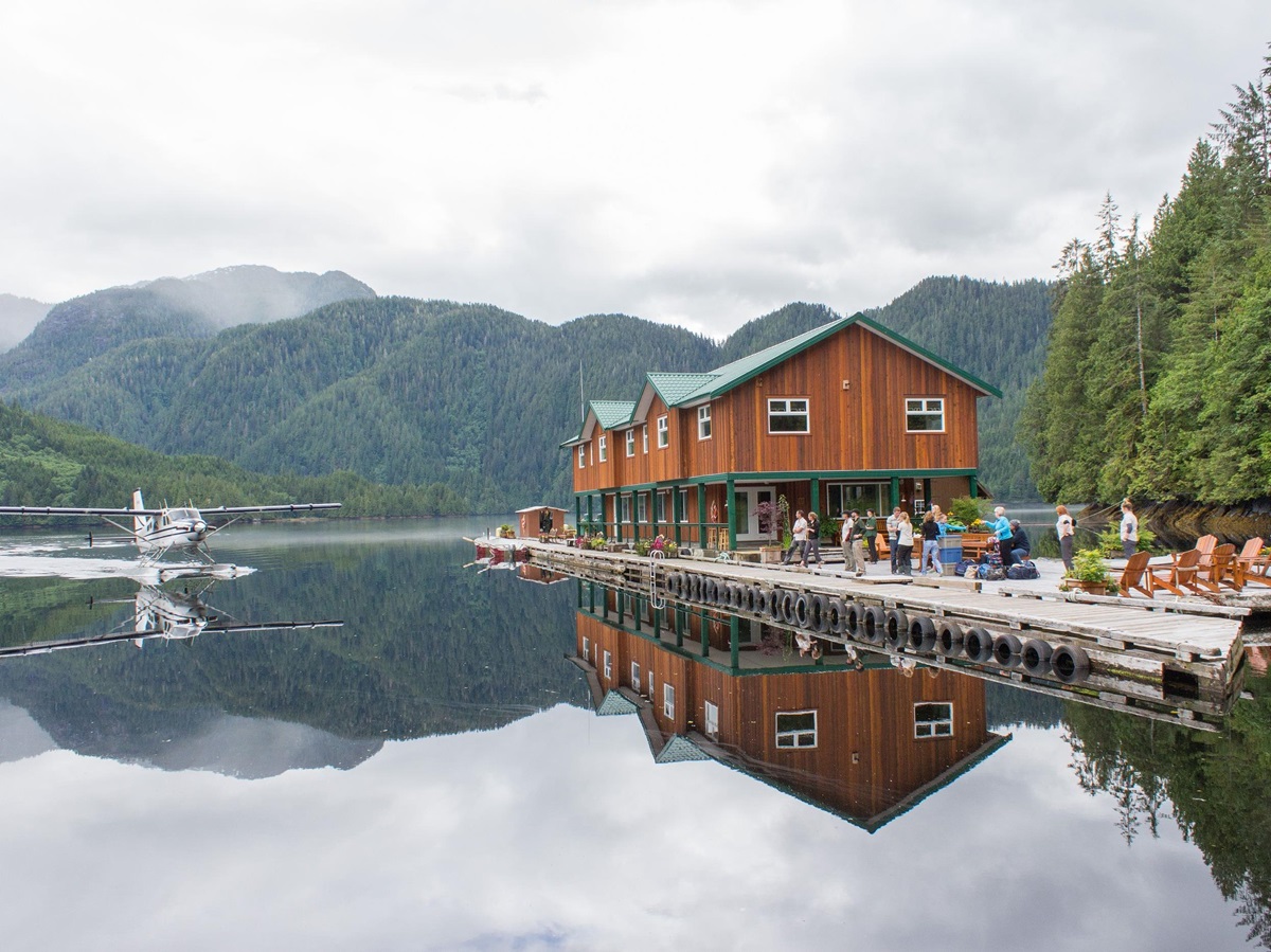 Seaplane Lodge with mountains in background reflecting in water, Great Bear Lodge, Canada