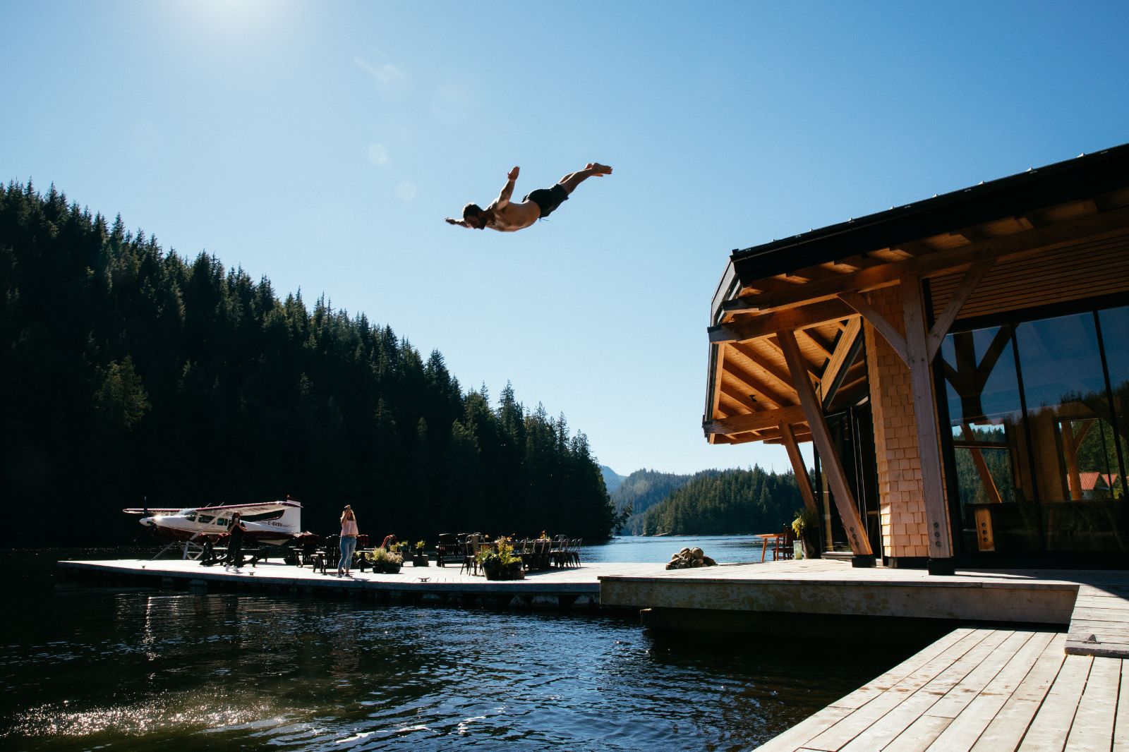 Deck jumping into the river on the grounds of Nimmo Bay Wilderness Resort in Canada's British Columbia region