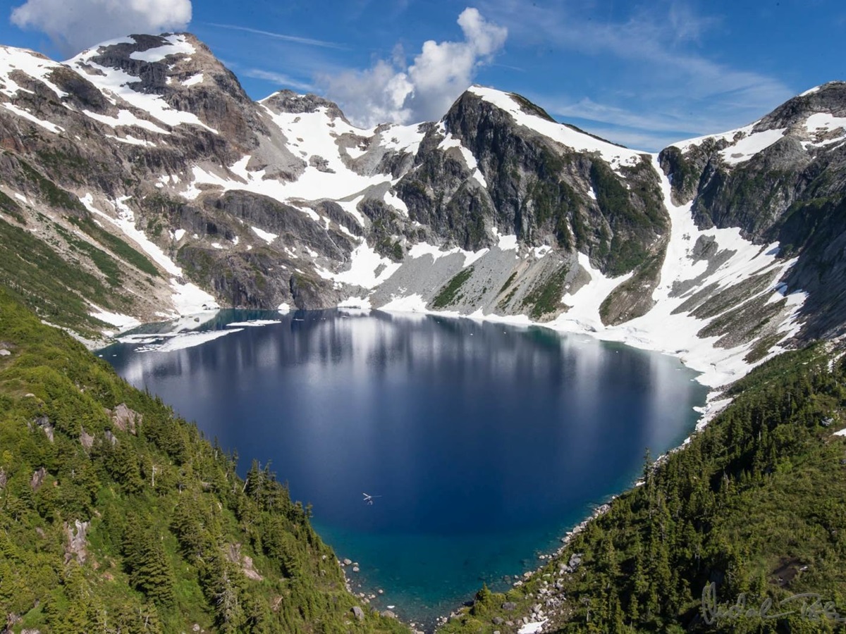 Snowy mountains and a valley with a large lake