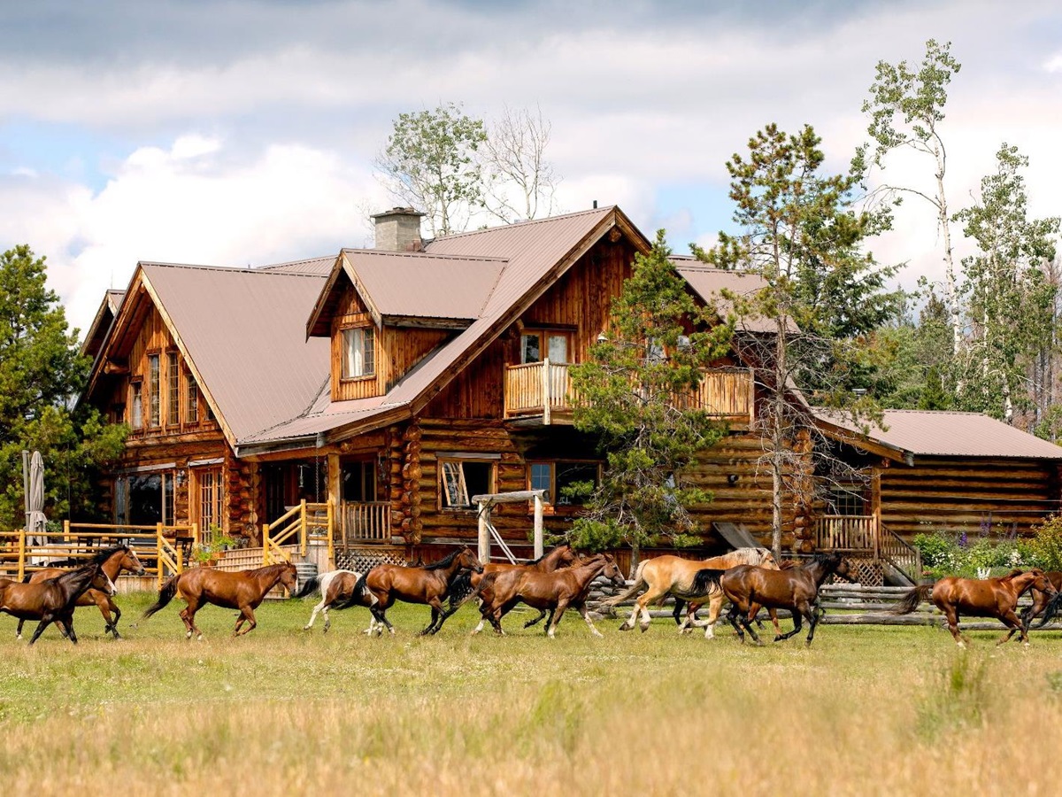 Horses running past the lodge on the grounds of Siwash Lake Ranch in Canada's British Columbia