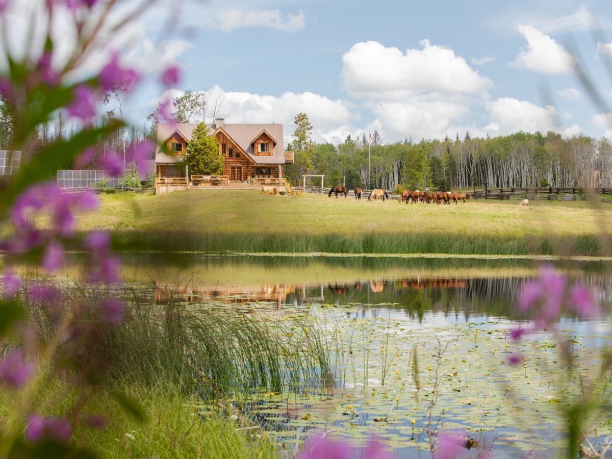 Exterior view of lodge, horses and lake at Siwash Lake Ranch in Canada's British Columbia