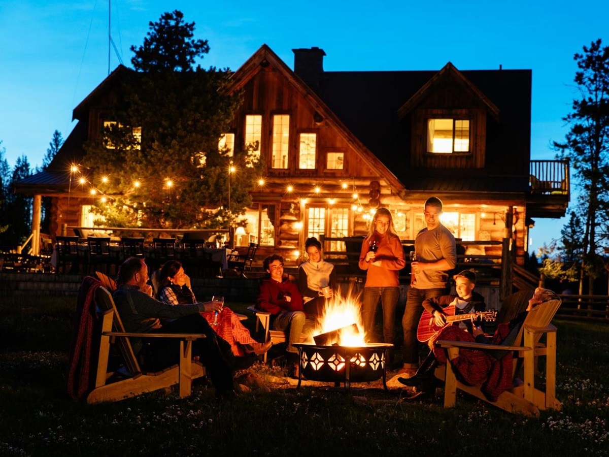 Guest gathered round the fire at night time at Siwash Lake Ranch in Canada's British Columbia