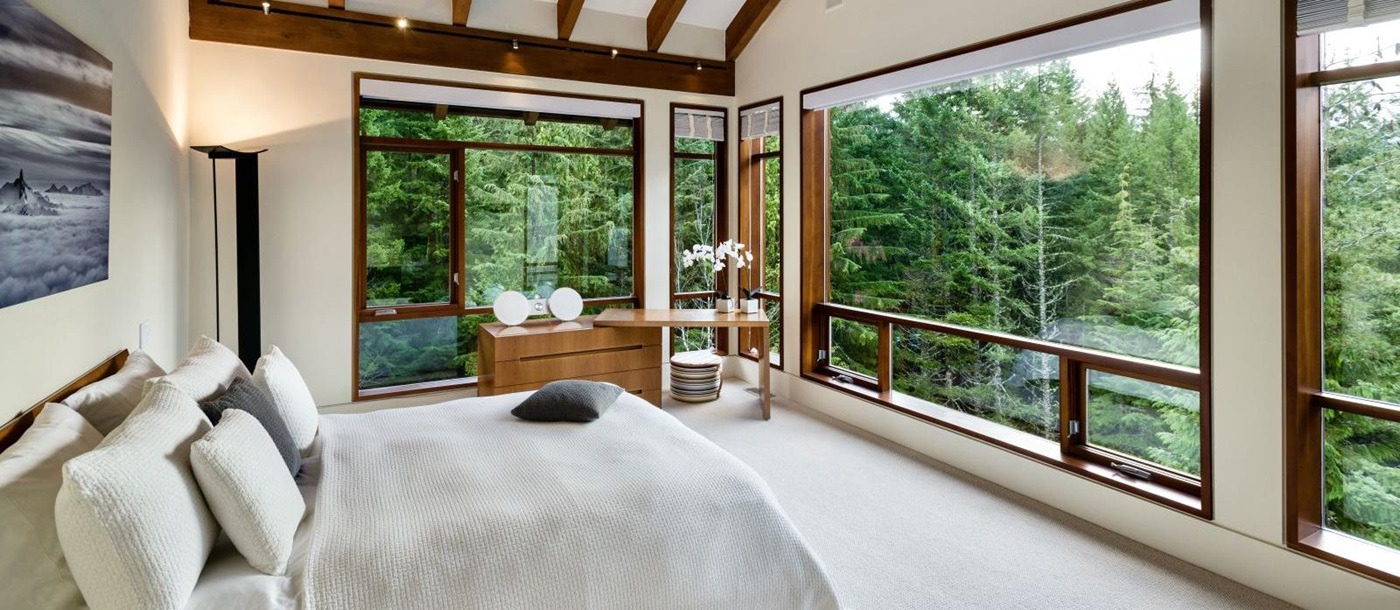 Double Bedroom with large windows overlooking the forest at luxury private home The Belmont Estate in Whistler, Canada