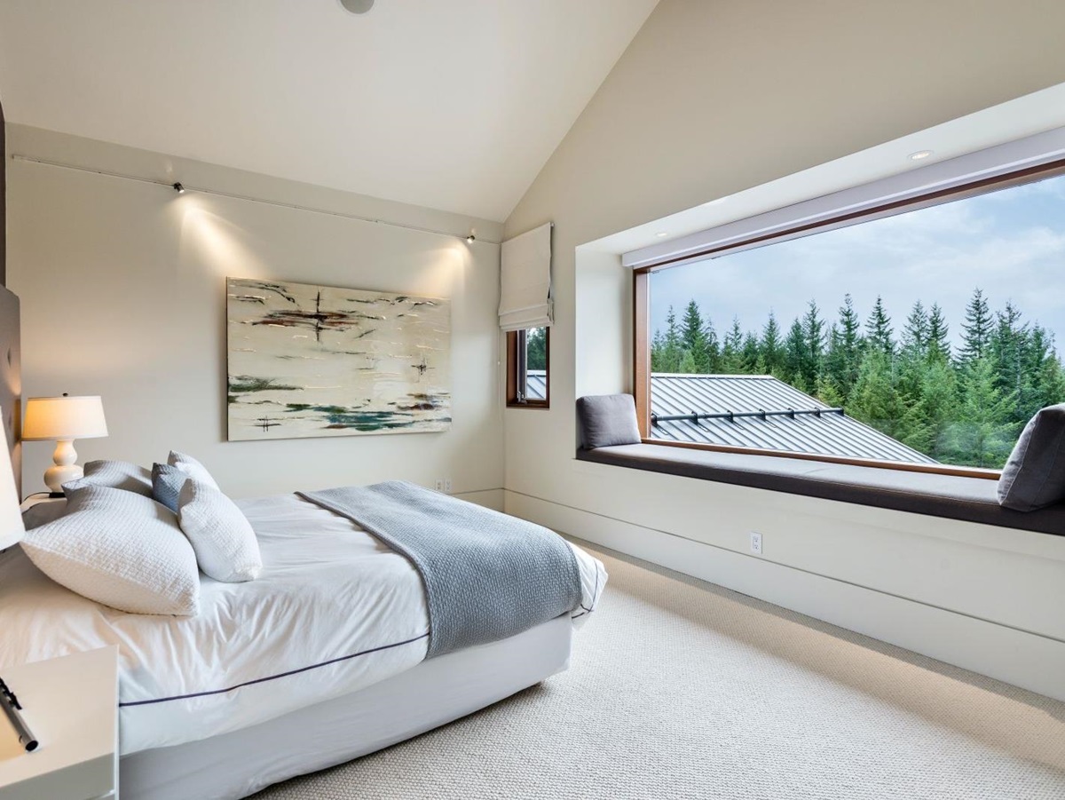 Double bedroom with large window overlooking the forest at luxury private home The Belmont Estate in Whistler, Canada