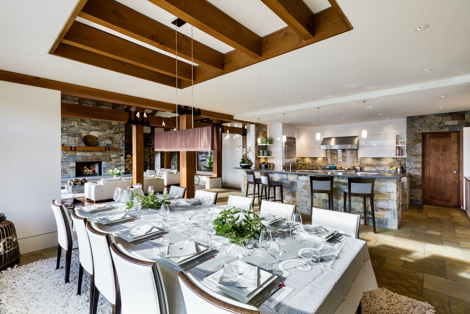 Set dining table with kitchen and bar in the background at luxury private home The Belmont Estate in Whistler, Canada