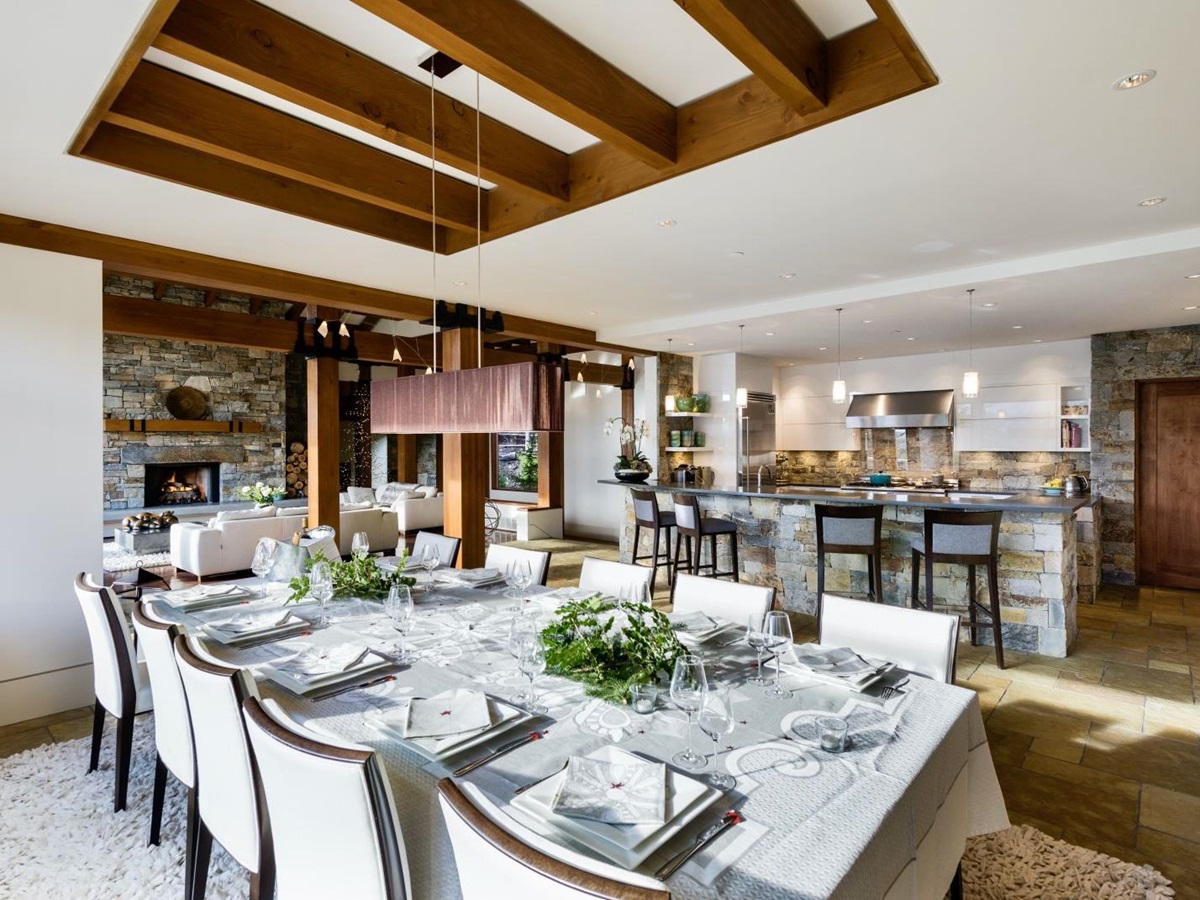 Set dining table with kitchen and bar in the background at luxury private home The Belmont Estate in Whistler, Canada