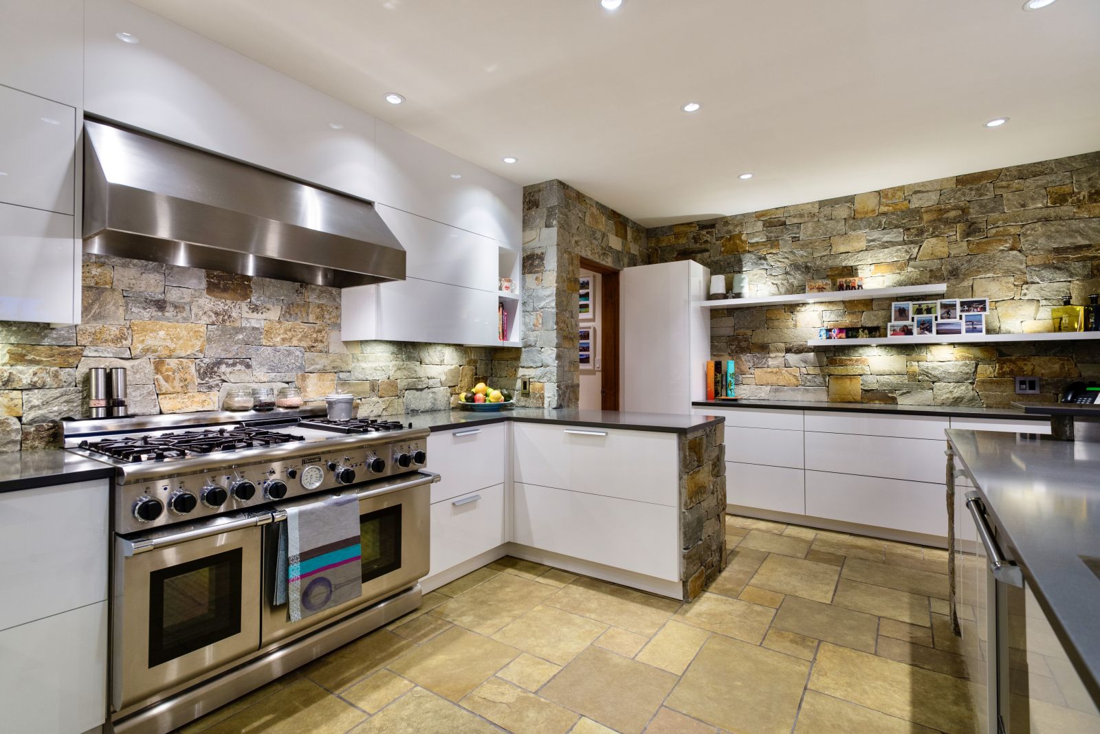 Extensive kitchen with natural stone walls at luxury private home The Belmont Estate in Whistler, Canada
