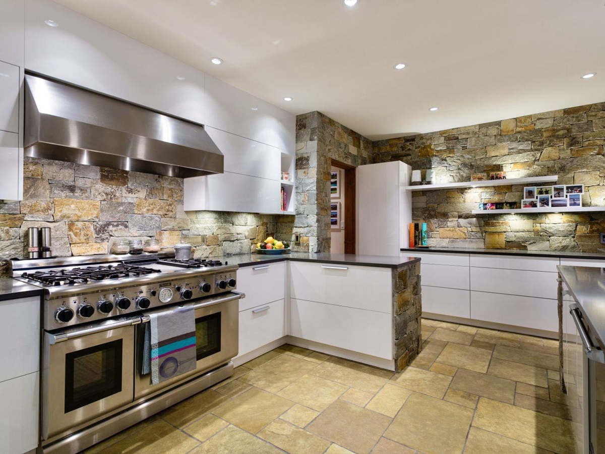 Extensive kitchen with natural stone walls at luxury private home The Belmont Estate in Whistler, Canada