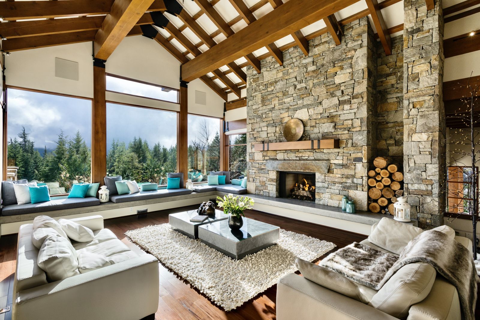 View from the comfortable lounge with fire place floor to ceiling windows at luxury private home The Belmont Estate in Whistler, Canada
