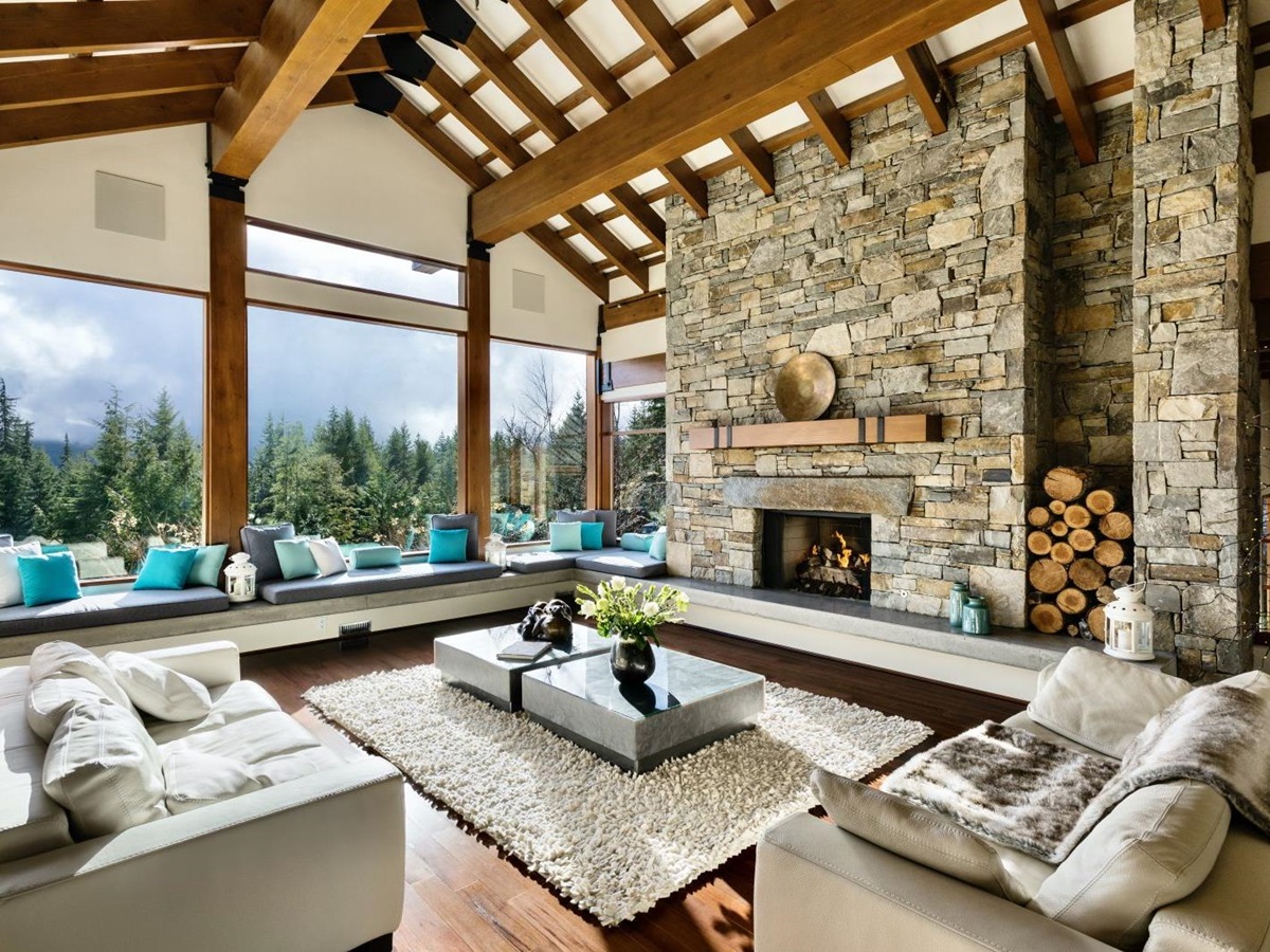 View from the comfortable lounge with fire place floor to ceiling windows at luxury private home The Belmont Estate in Whistler, Canada