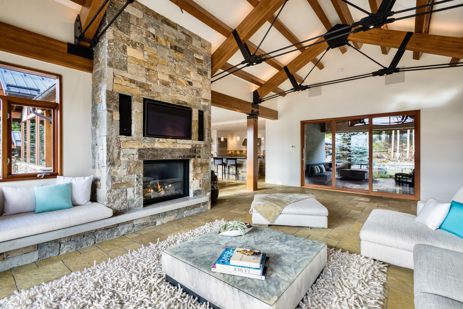 Comfortable lounge with fireplace and TV at luxury private home The Belmont Estate in Whistler, Canada
