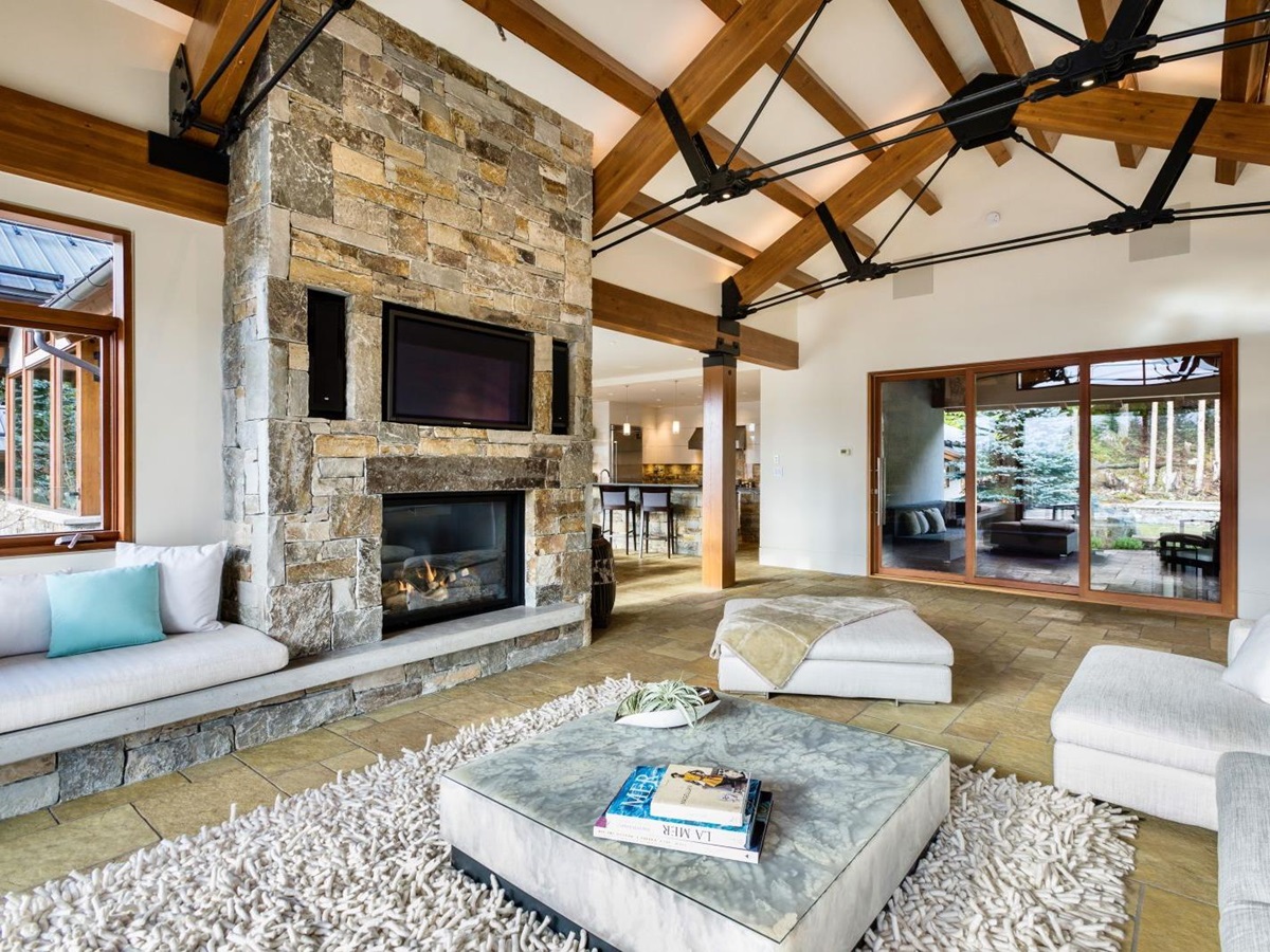 Comfortable lounge with fireplace and TV at luxury private home The Belmont Estate in Whistler, Canada