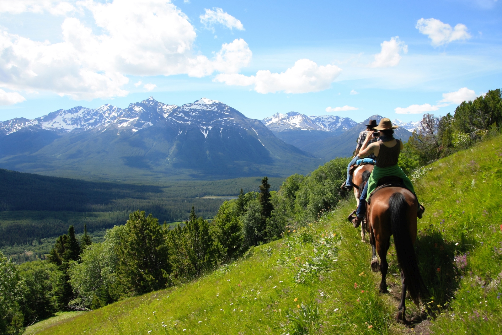 A group of horse riders and a view of a mountain range