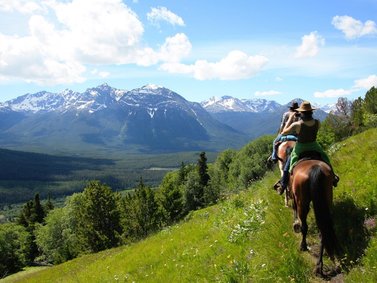 A group of horse riders and a view of a mountain range