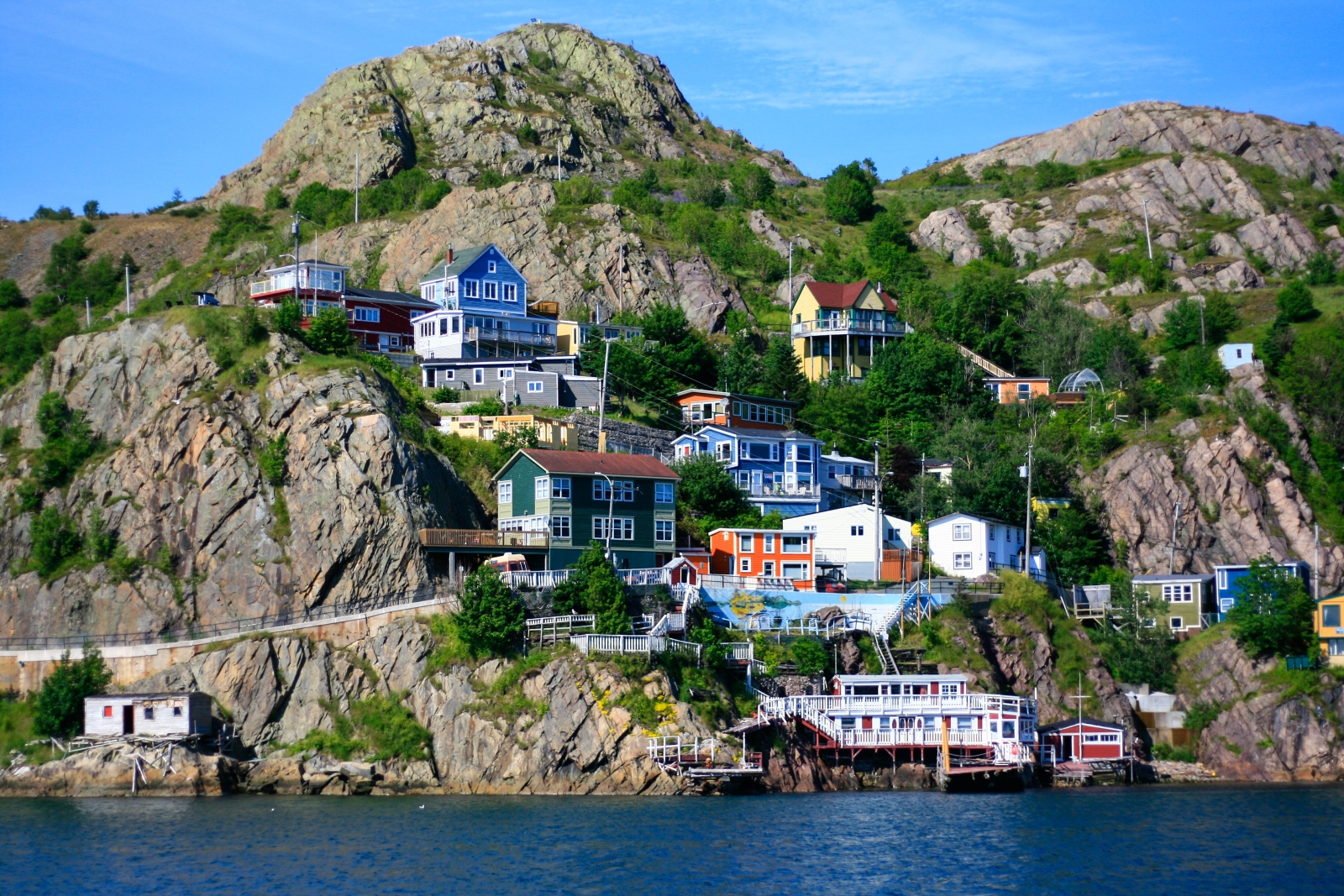 Cliffside with coloured buildings and boats at St Johns