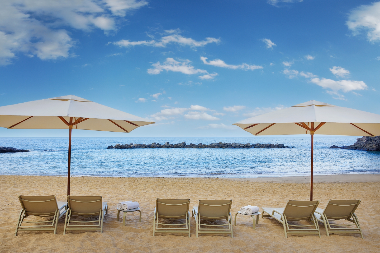 Sunloungers and parasols on the beach of luxury resort Ritz Carlton Abama on Tenerife