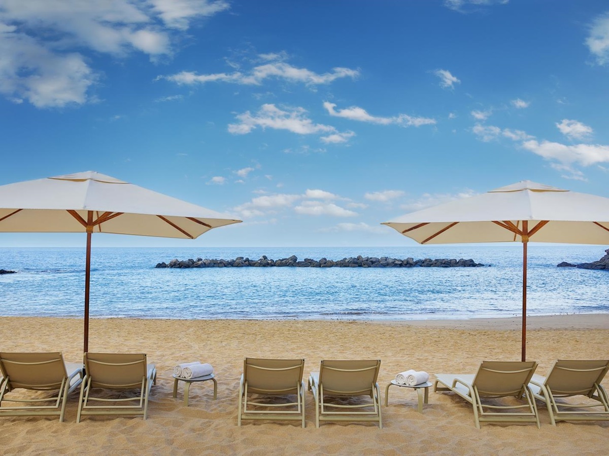 Sunloungers and parasols on the beach of luxury resort Ritz Carlton Abama on Tenerife