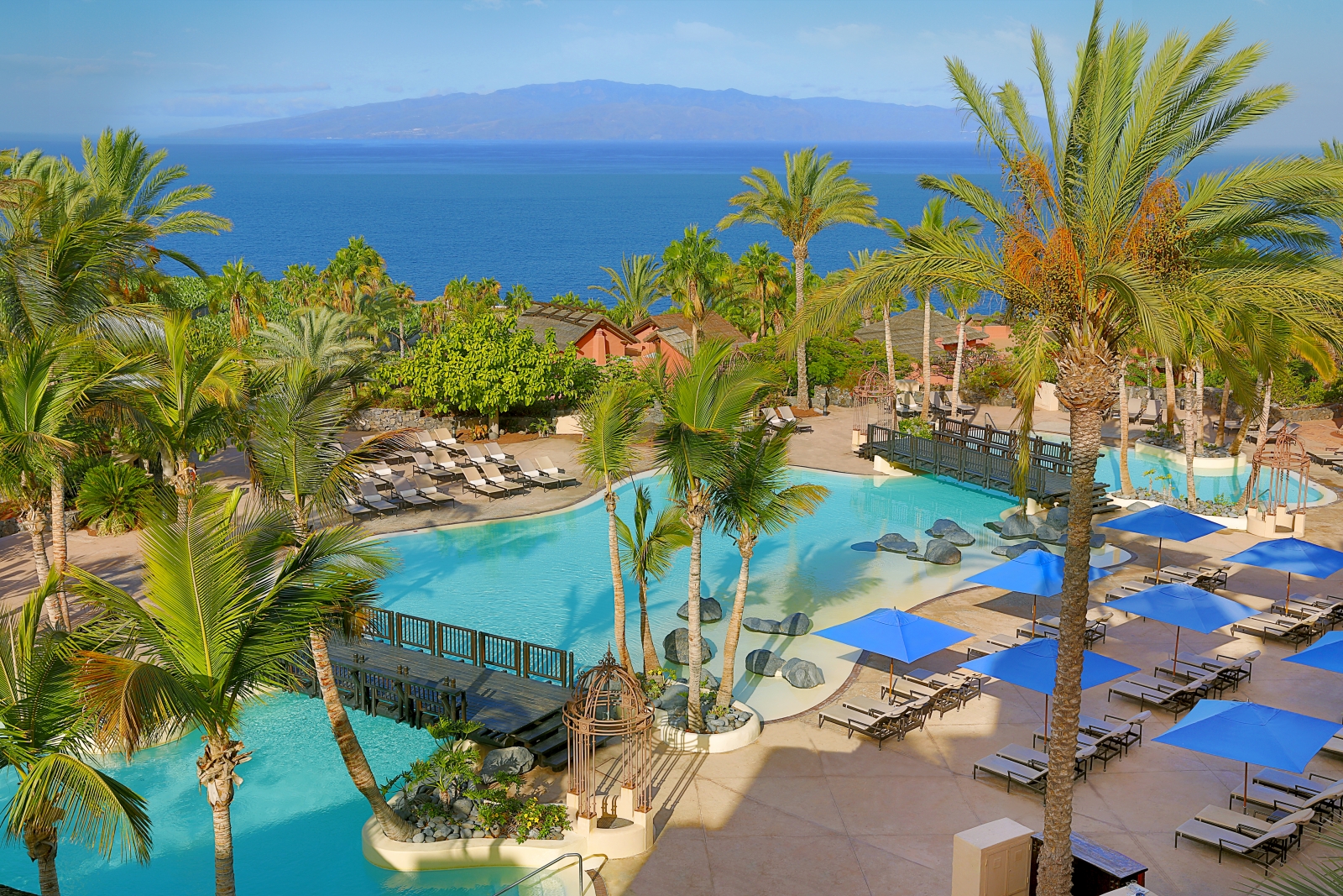 Sun loungers, parasols and palms strewn around the main pool at luxury resort Ritz Carlton Abama on Tenerife