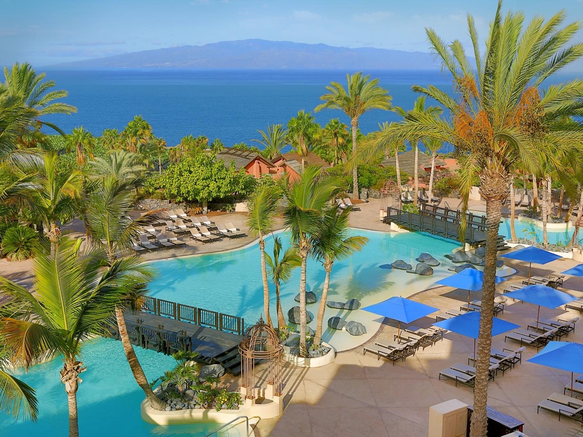 Sun loungers, parasols and palms strewn around the main pool at luxury resort Ritz Carlton Abama on Tenerife