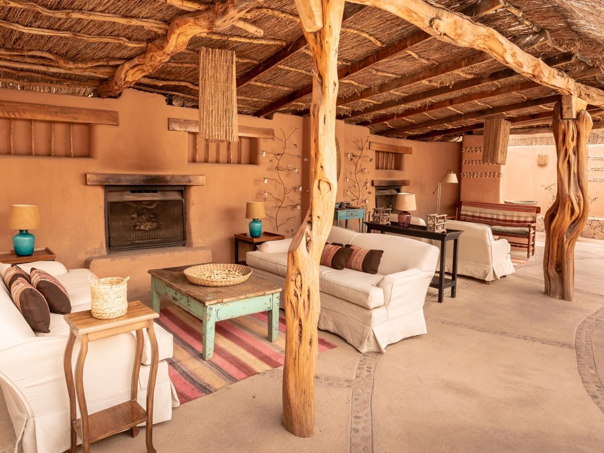 Lounge area with fireplace at Awwasi Atacama