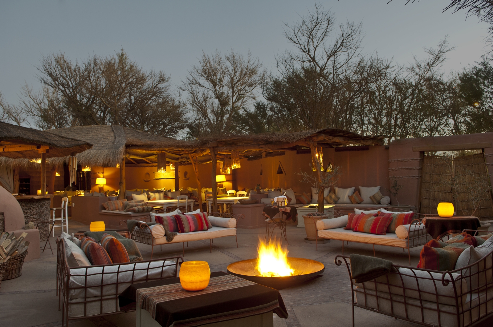Outdoor lounging area at night with bonfire at Awasi Atacama