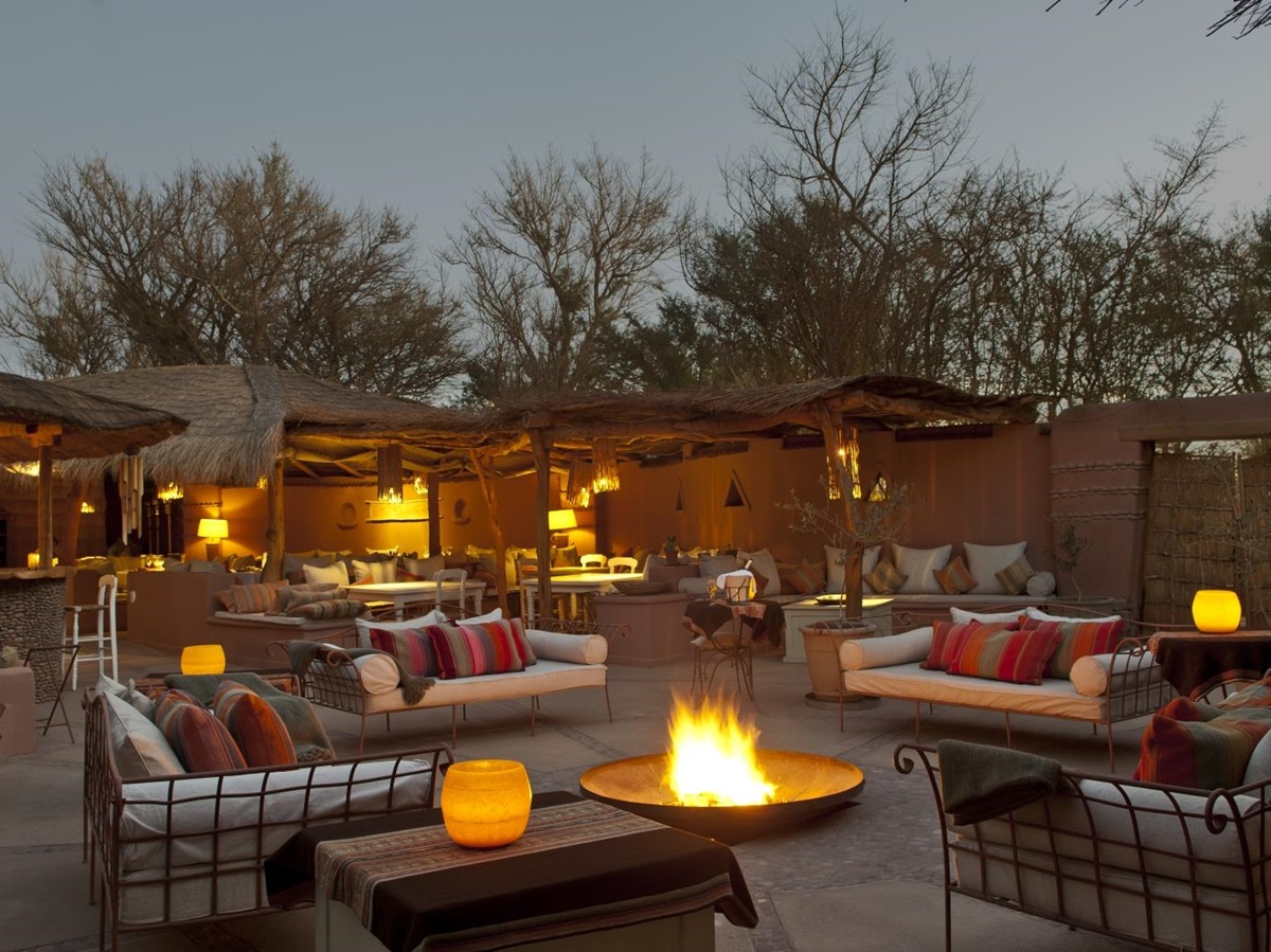 Outdoor lounging area at night with bonfire at Awasi Atacama