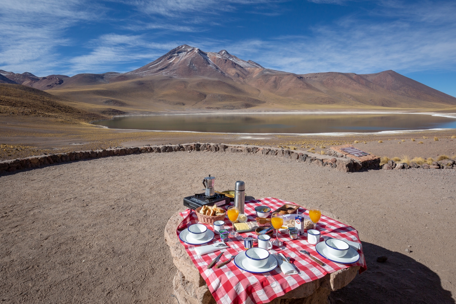 Breakfast set up by a lake and mountain in the Atacama Desert