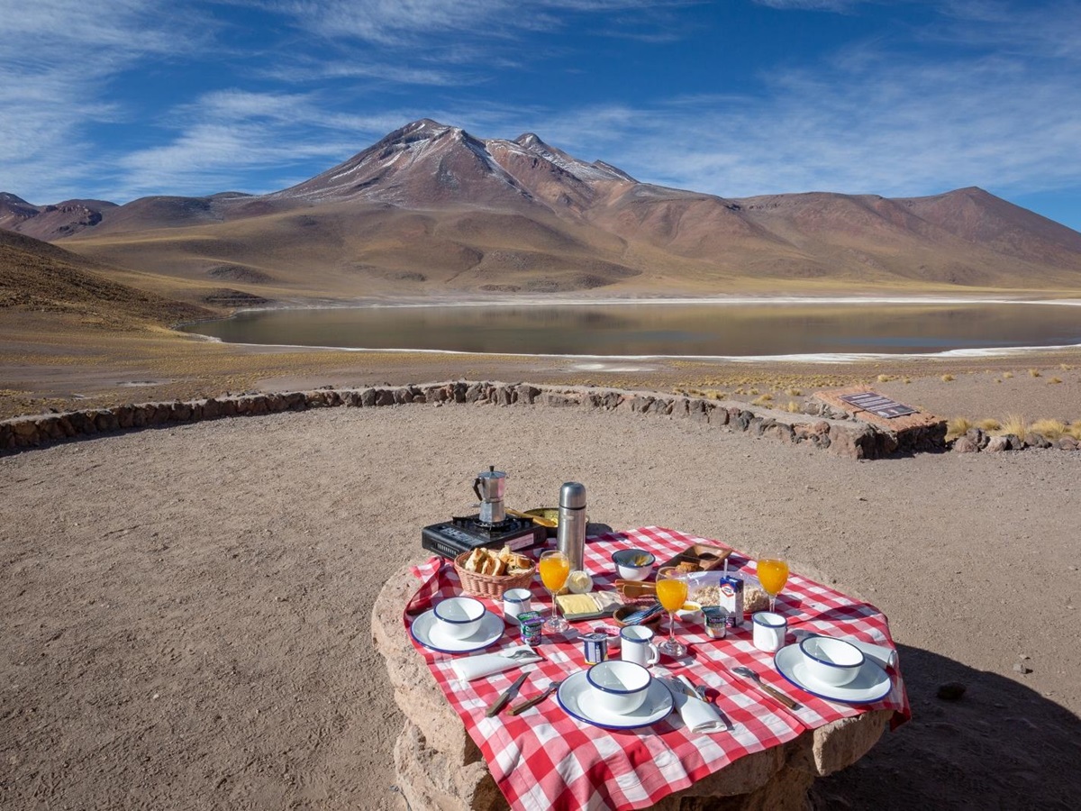 Breakfast set up by a lake and mountain in the Atacama Desert