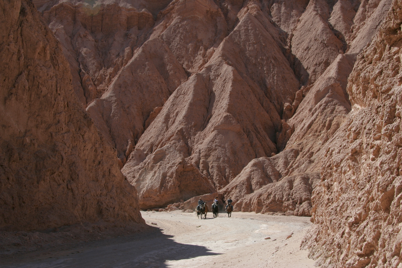Three riders in a valley in the Atacama desert