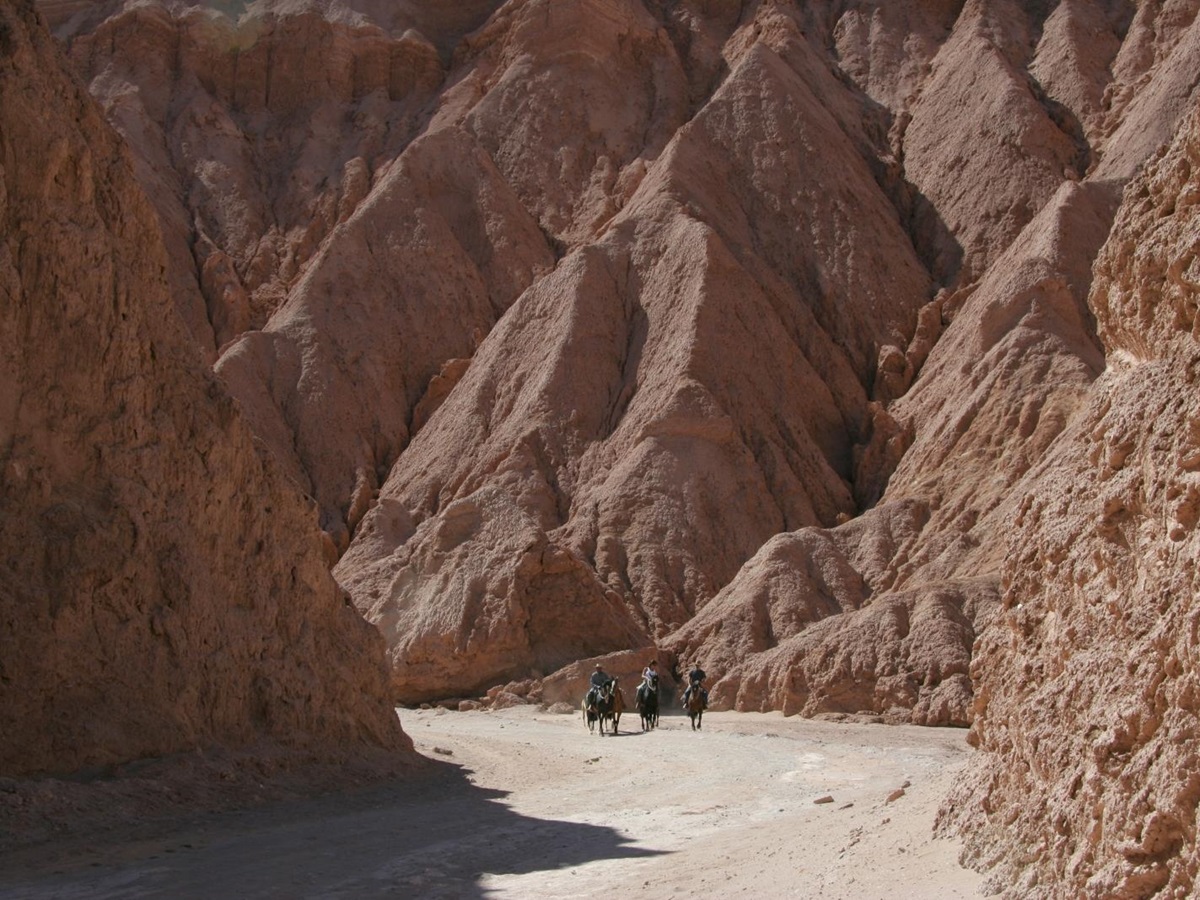 Three riders in a valley in the Atacama desert