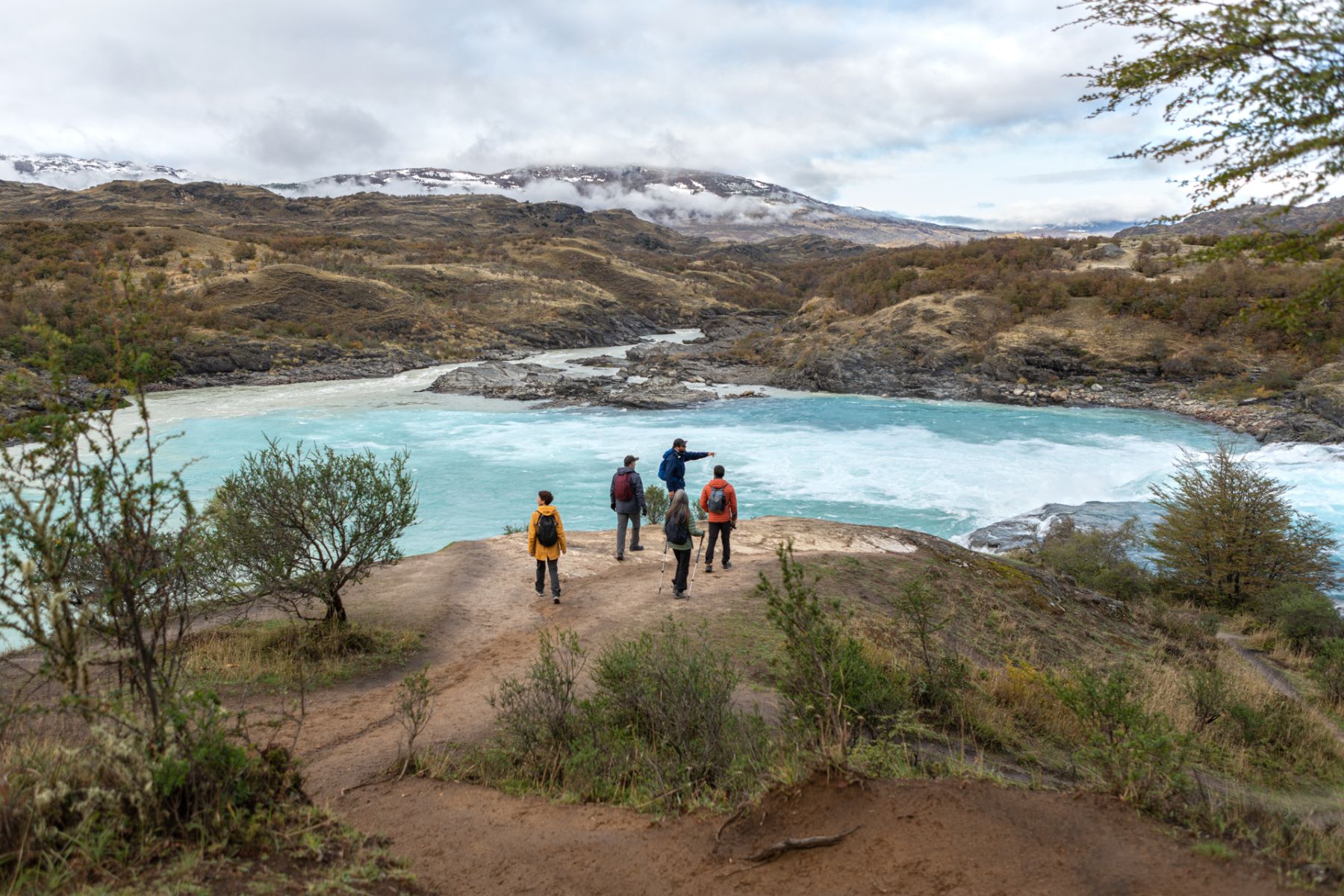 Guests hiking alongside a rushing river on excursion from Explora Patagonia National Park in Chile