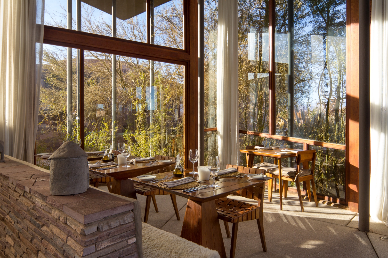 Three individual dining tables in a separée with floor-to-ceiling windows