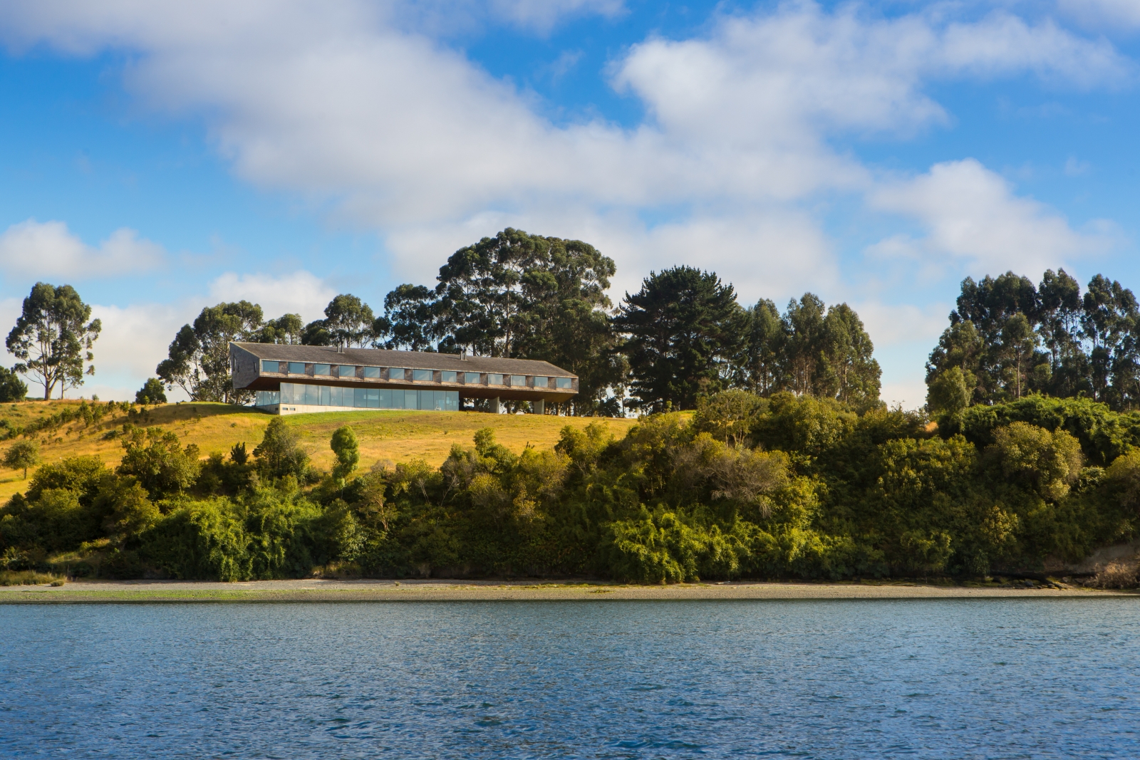 Exterior view of Tierra Chiloe on a hill overlooking a lake