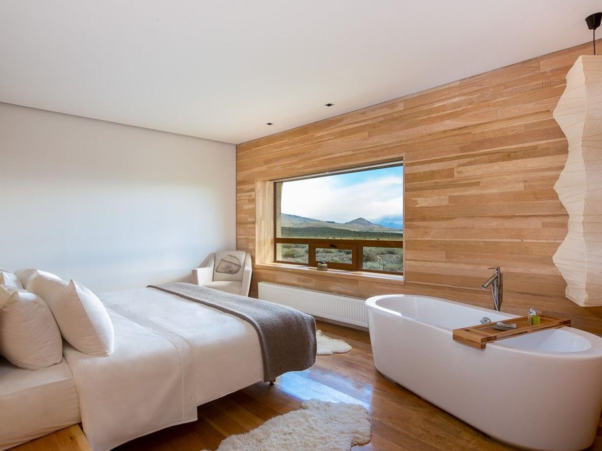 Double bedroom with bathtub and mountain views at Tierra Patagonia, Chile