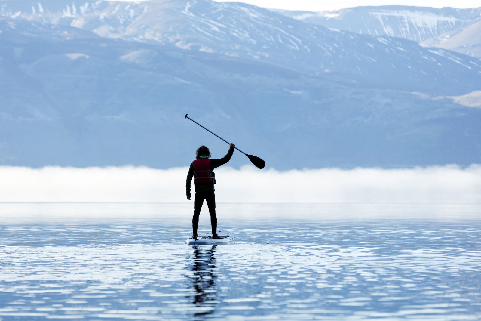 Guest at Patagonia Camp stand-up paddle boarding on Lake Toro in Chile