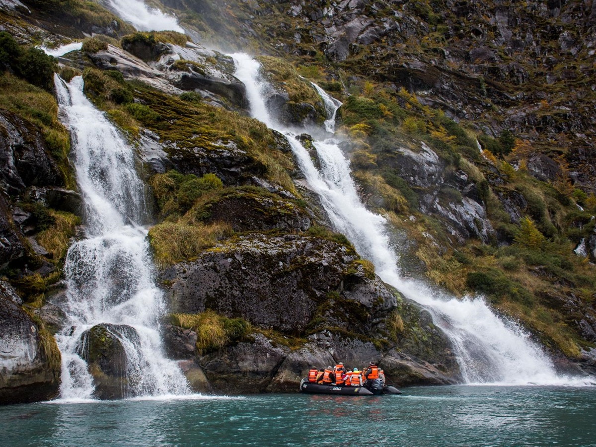 Guests of the the Stella Australis Patagonia observing waterfalls from a Zodiac