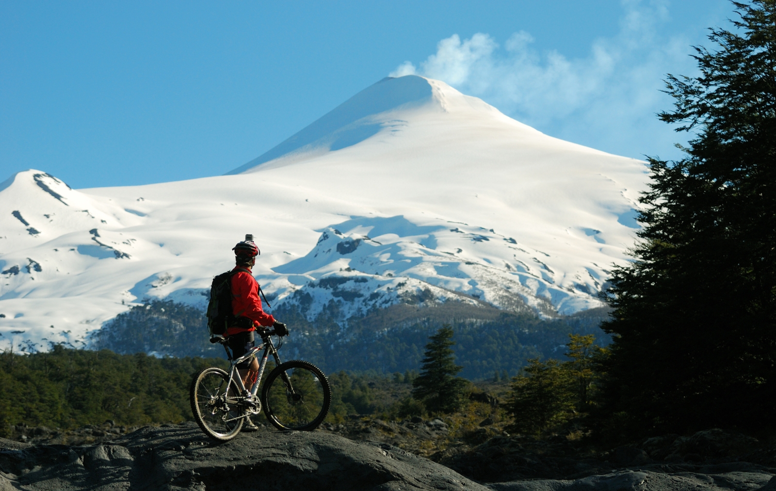 Cyclist looking at snowy mountains